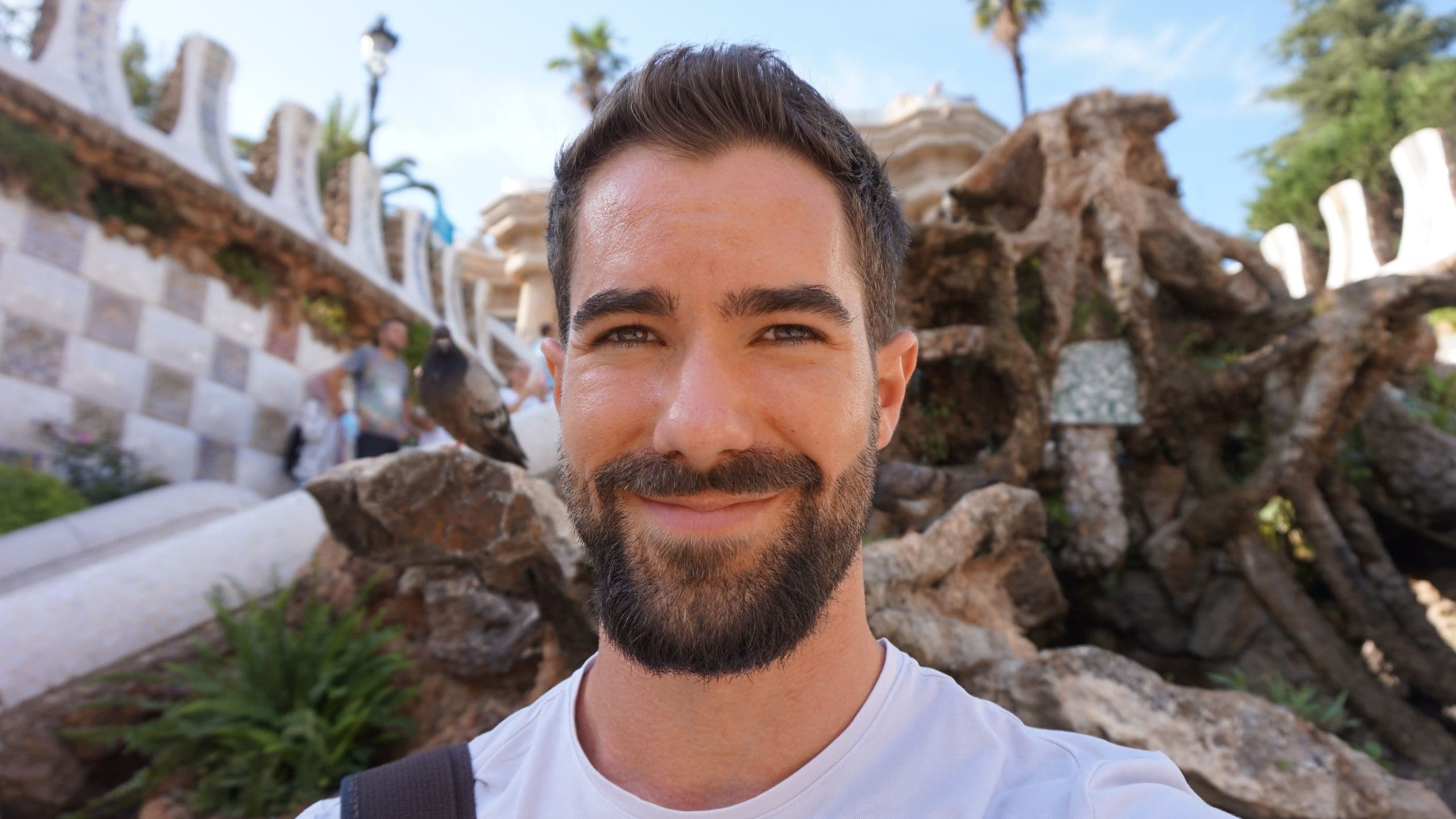 Nikjas Sakowski lächelt in die Kamera, im Hintergrund Park Güell